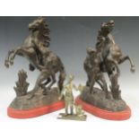 A pair Marley horses on red painted wooden plinths, 43 x 33 x 18cm; together with a brass figure