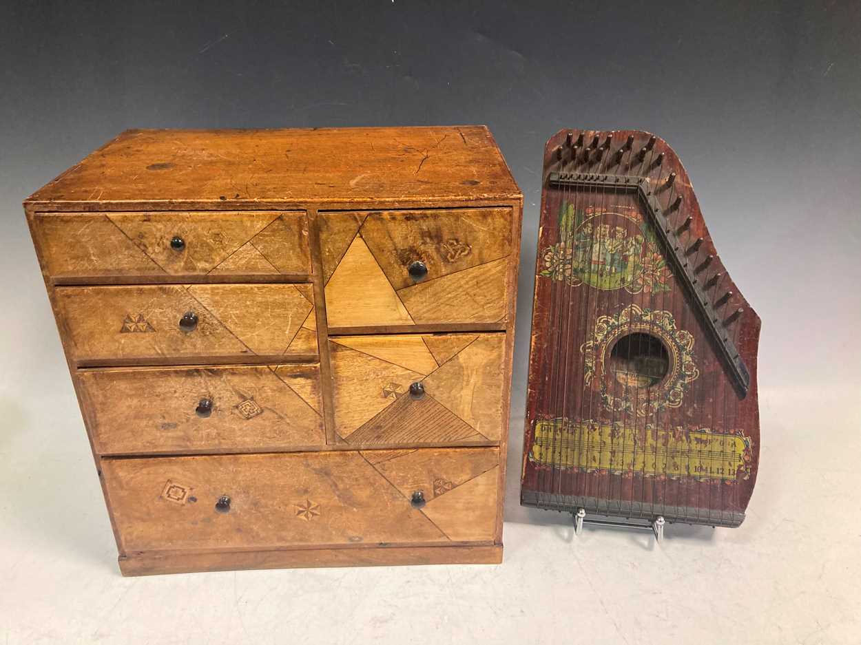 A small parquetry inlaid chest of drawers, 33.5 x 33 x 22cm, and a small zither (2)