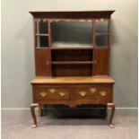 A late 18th century oak dresser, the associated plate rack with a shaped frieze over various shelves