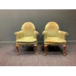 A pair of Queen Anne style armchairs on shell carved cabriole legs upholstered in a green damask