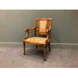 An Edwardian inlaid mahogany armchair on square tapered legs and spade feet