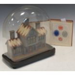 A late Victorian model villa under a glass dome on stand and a small album of crests (dome approx