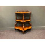 A Victorian figured walnut three shaped tier whatnot with decorative pierced carved back galleries