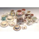 A large collection of Poole Pottery, including teacups, saucers and jugs