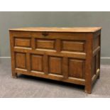 A late 17th century oak chest, the three plank cleated top with iron loop hinges above a panelled