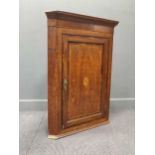 A late George III inlaid oak hanging corner cupboard, the single door with central fan inlay105.5