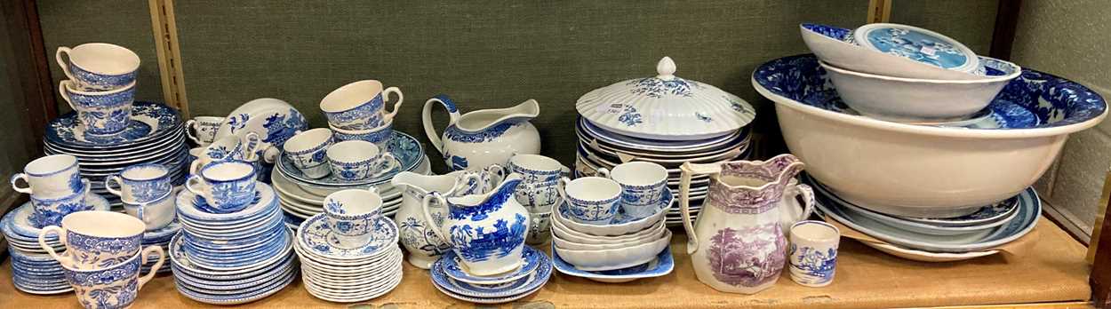 A large collection of blue and white transfer printed wares together with some commemorative mugs