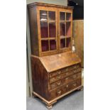 A walnut bureau bookcase, 18th century and later,the later glazed top section above a fall front
