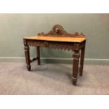 A Victorian 17th century style carved oak side table, the carved arched gallery with a central dog