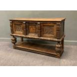 A 17th century style oak marquetry side cabinet, the two plank top above three carved cupboard