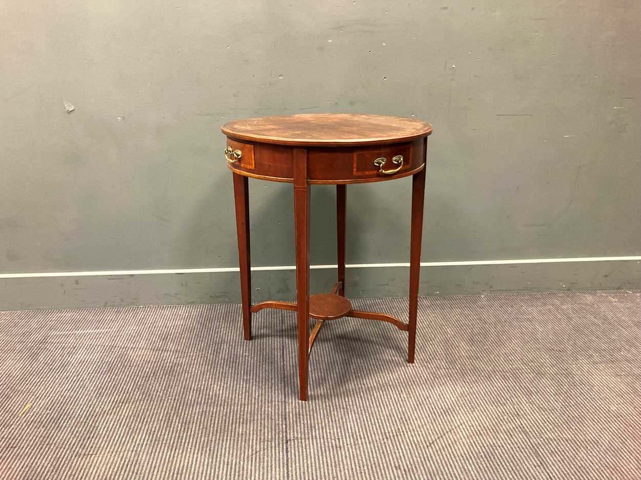 An Edwardian mahogany circular occasional table with two real and two ...