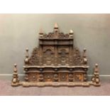 An Elizabethan-style carved oak overmantle decorated with fretwork and geometric panels, stamped '