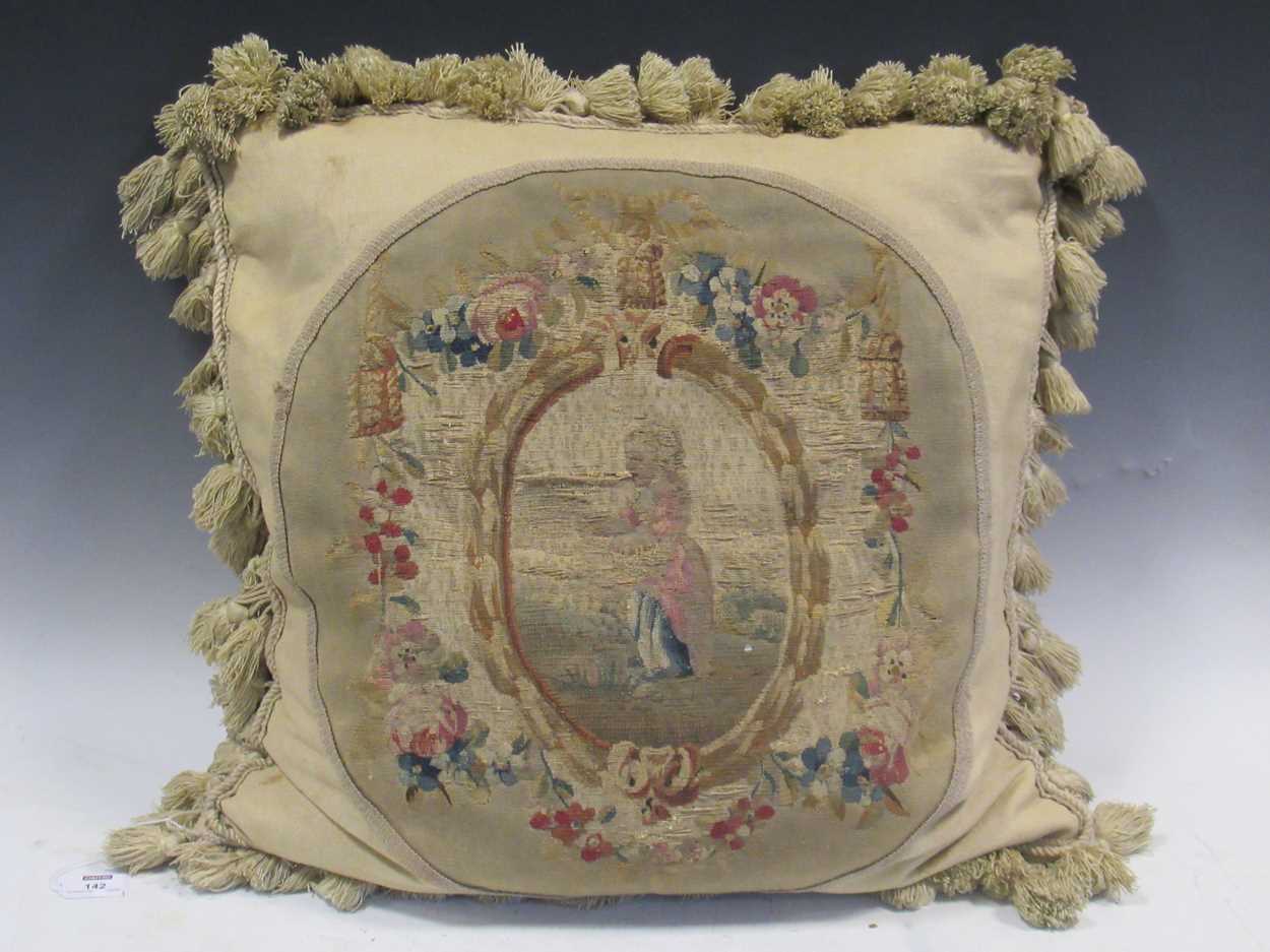An 18th century Aubusson needlework applied to a later cushion, decorated with a young girl within a