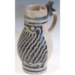 An 18th-century Westerwald jug, the body with incised decoration, 25cm high