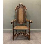 A William and Mary style walnut armchair with a caned back and seat