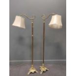 A pair of brass standard lamps, early 20th century, on cast triform bases, converted for