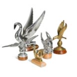 A group of five brass and chrome car mascots,