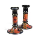 A pair of Moorcroft Pomegranate pattern candlesticks,