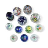 A collection of John Deacons and other glass paperweights,