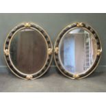 A pair of 20th century gilt and black oval wall mirrors 110 x 93 cm