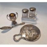 A small collection of silverware including a two handled trophy cup, hand mirror, silver topped
