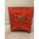 A red and black lacquer cabinet painted with a village in a landscape, 78 x 59 x 37cm