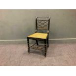 A Regency style ebonised faux-bamboo chair with caned seat and gilt ball decoration, 84 x 46 x 52cm