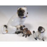 A large Meissen model of a pug dog and puppy, 17cm high; two further Meissen models of pug dogs, 7cm