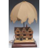 A Cecil Aldin ceramic model of a country inn 19.5 x 23 x 12cm, on a wooden plinth with raised lamp