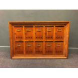 A 20th century oak post box wall cabinet, comprising of ten post boxes with hinged doors, 48.5 x 129