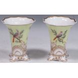 A pair of Copeland and Garrett porcelain vases, painted with birds on a yellow-green and gilt