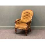 An early Victorian button back easy armchair on turned legs and castors