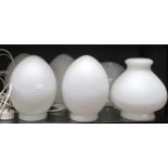 Four 1980's egg form white opaque glass lamps, together with one sectional ovoid lamp and a white