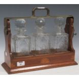A tantalus with three cut glass decanter, the carry case with inlaid details, 31 x 40 x 15cm Not