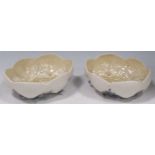A pair of Belleek bowls, moulded with shells and seaweed, black marks, 18cm wide One with a bad