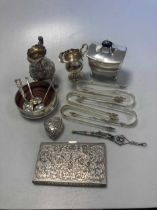 A collection of silverware including sugar nips, tea caddy, cram jugs, bottle coaster etc together