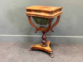 A Regency flame mahogany work table, the hinged lid enclosing a fitted interior on lion paw feet