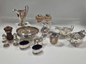 A collection of silverware including cruets, sauce boats, cream jugs, table lighter, bowl etc.,