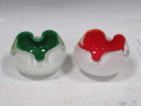 A pair of Murano cased glass ashtrays, one in white and red, the white and green, 14cm diameter