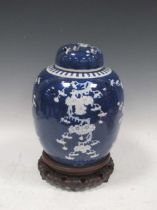 A Chinese blue and white ginger jar and cover, 32cm high, on a harwood stand The lid is a/f - broken