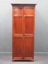 An early 19th century mahogany cupboard with four-panel doors on bun feet, 214 x 93 x 57cm