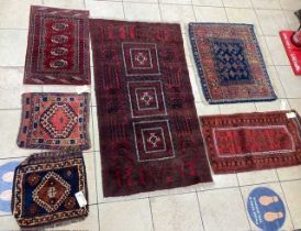 A red ground Persian rug with three square sectioned central field, three small tribal rugs, and two