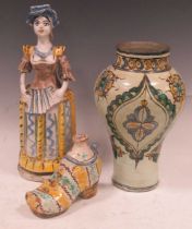 A large Maiolica figural candlestick, a Maiolica shoe-form flagon and another vase Severe chipping