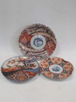 Three Japanese Imari plates, one decorated halfway fan divide, all decorated with blossoms, birds