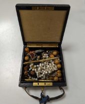 A Bramah travelling jewellery box containing a quantity of silver and costume jewellery, two strands