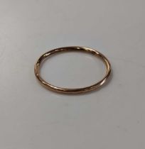 An arm bangle stamped '9ct', weight 9.5g