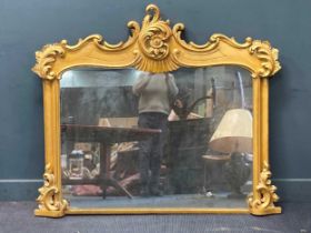 A Victorian style gilt wood overmantel mirror surmounted by a scrolling leaf and flower head 130 x