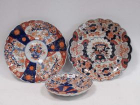 Three Japanese Imari plates with scalloped rims decorated with flowers, blossoms, butterflies and