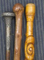 An Edwardian silver topped swagger stick together with two wooden walking sticks and a leather