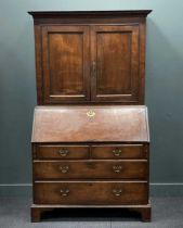 A Georgian oak bureau bookcase, the moulded cornice above a pair of cupboard doors over a fall front